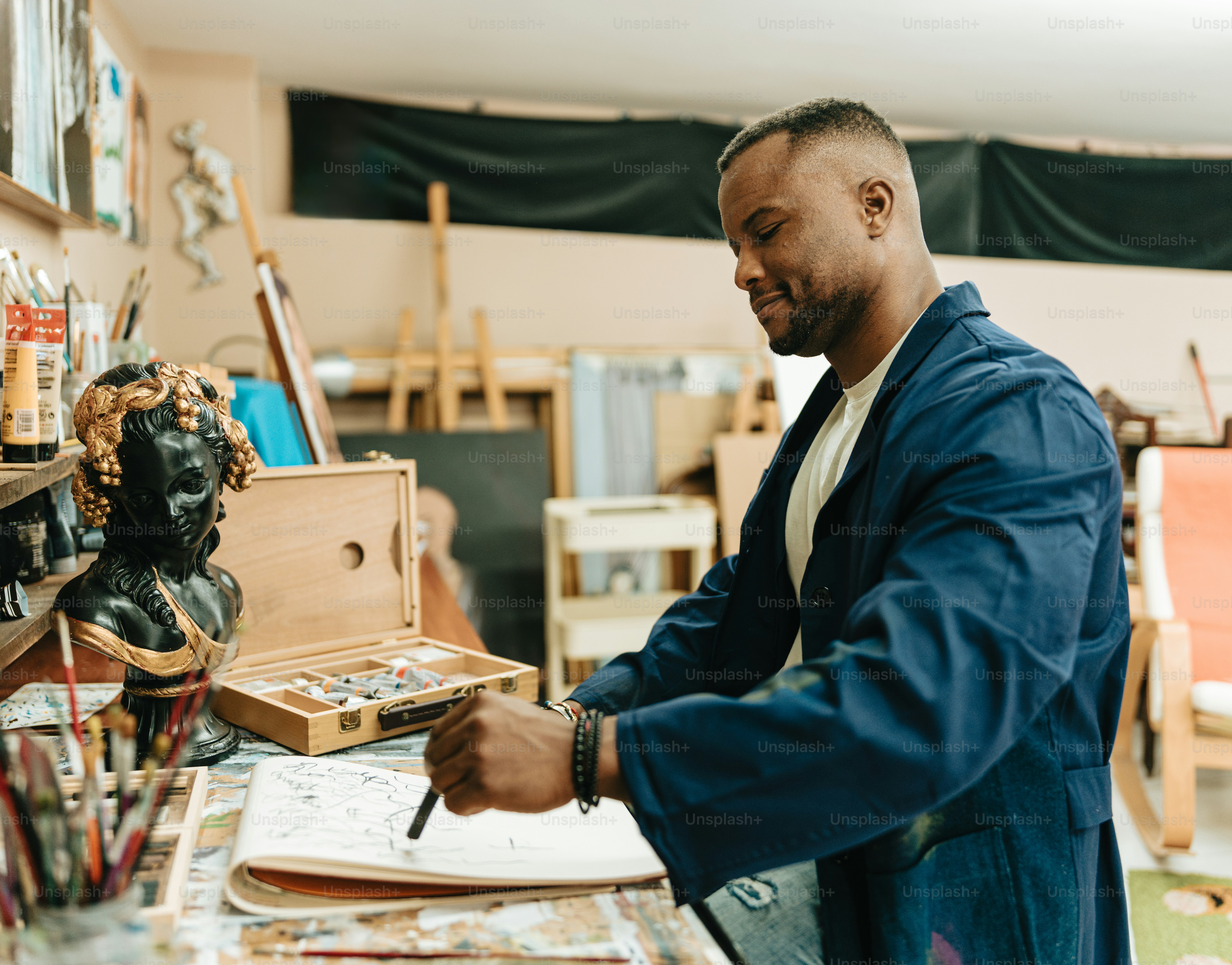 a man in a blue jacket is writing on a piece of paper