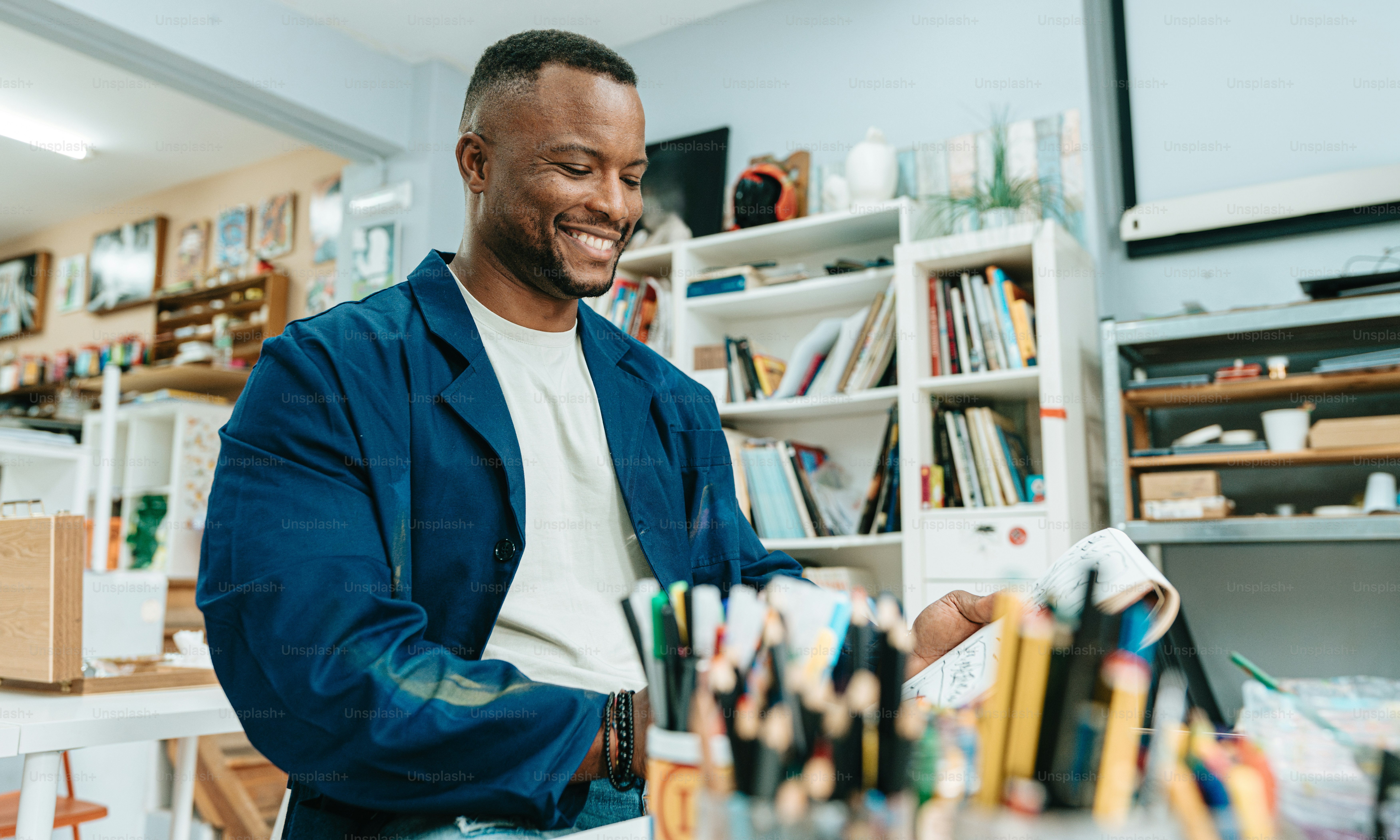 un homme assis à une table avec un tas de livres