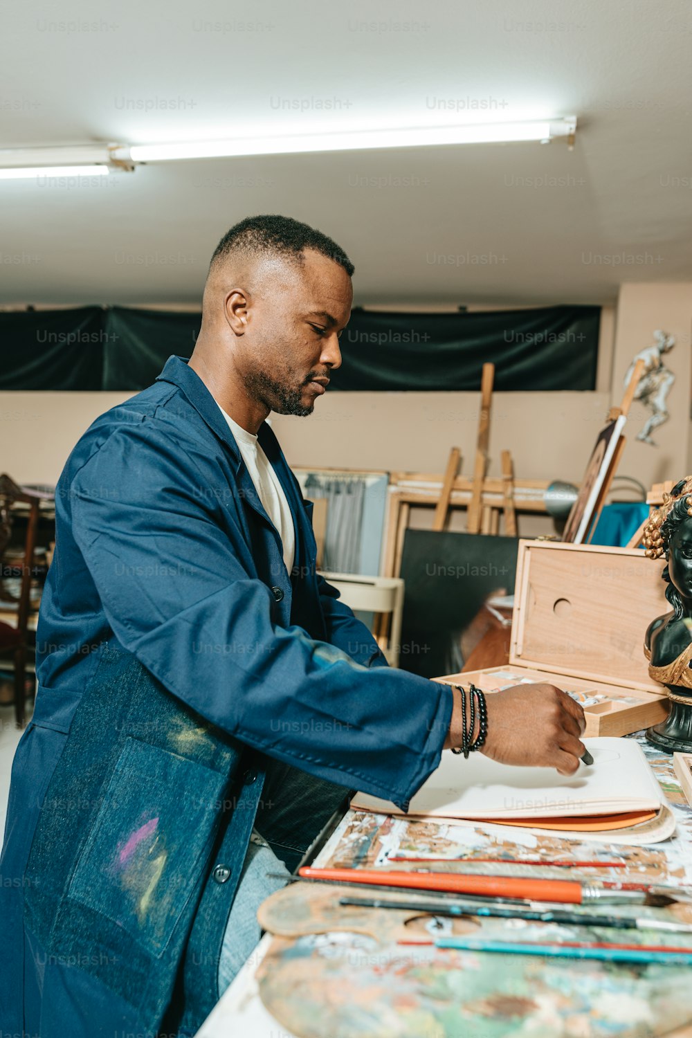Un hombre está trabajando en una pintura en un estudio