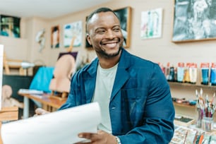 Ein Mann lächelt, während er ein Blatt Papier in der Hand hält
