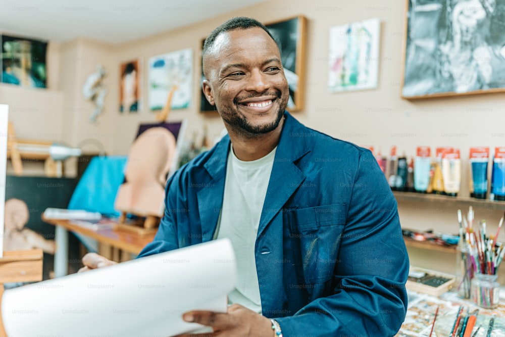 a man smiles while holding a piece of paper