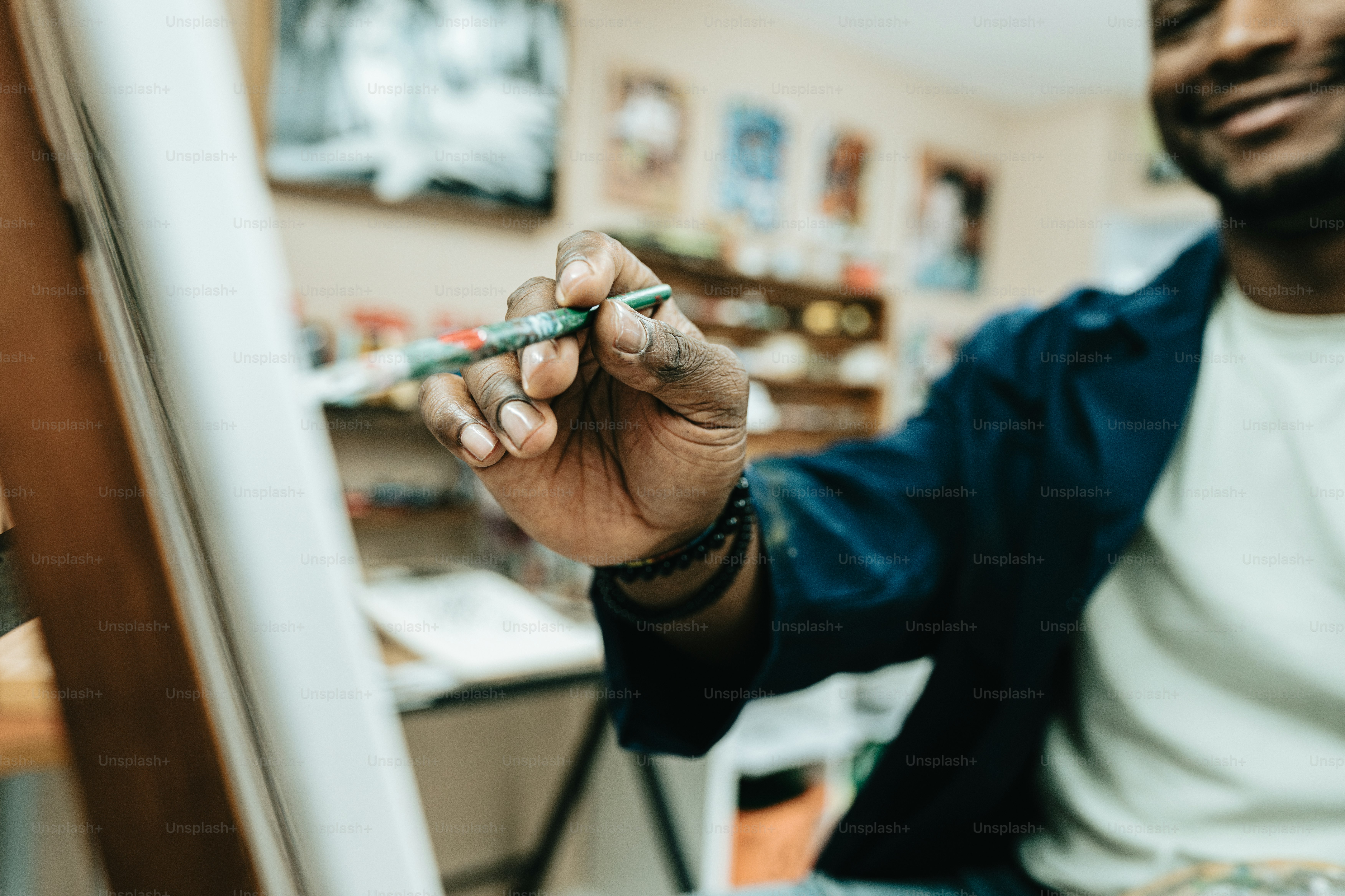 un homme assis devant un miroir tenant un stylo