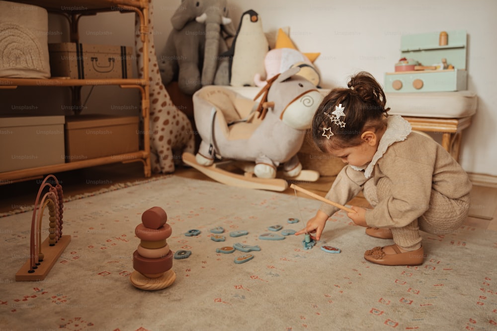 uma menina brincando com brinquedos em um quarto