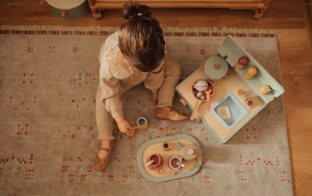 uma menina brincando com um conjunto de cozinha de brinquedo
