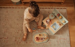 a little girl playing with a toy kitchen set