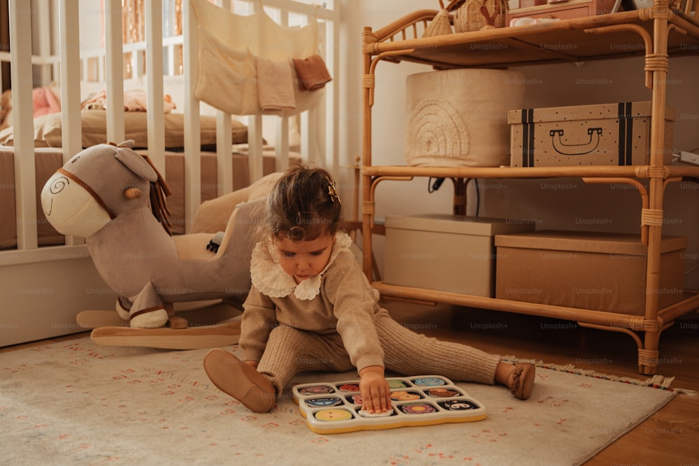 ein kleines Mädchen, das mit einem Buch auf dem Boden spielt