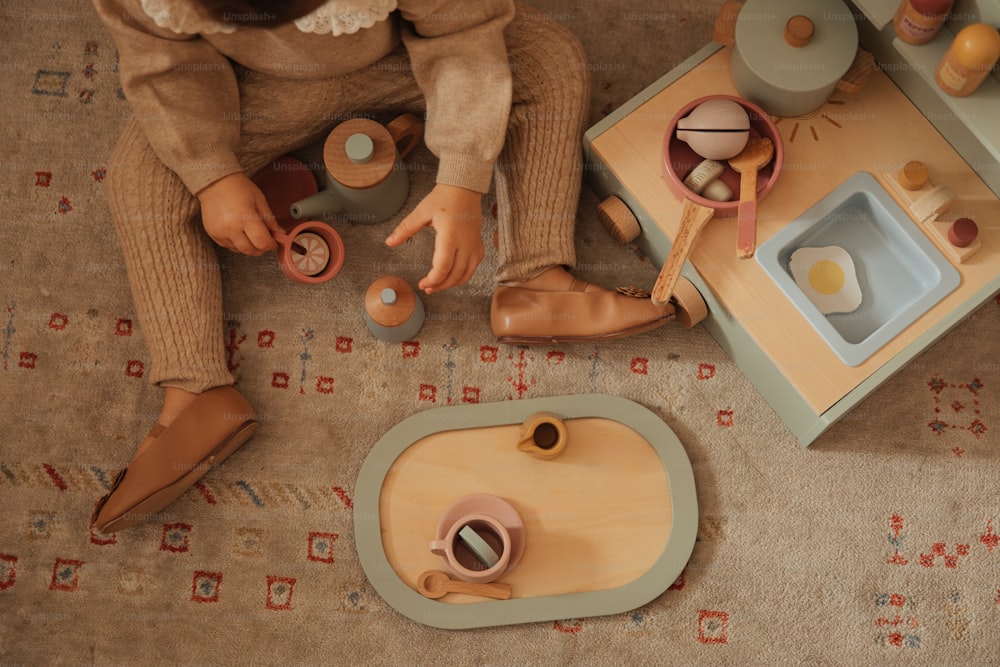une petite fille assise sur le sol jouant avec des jouets