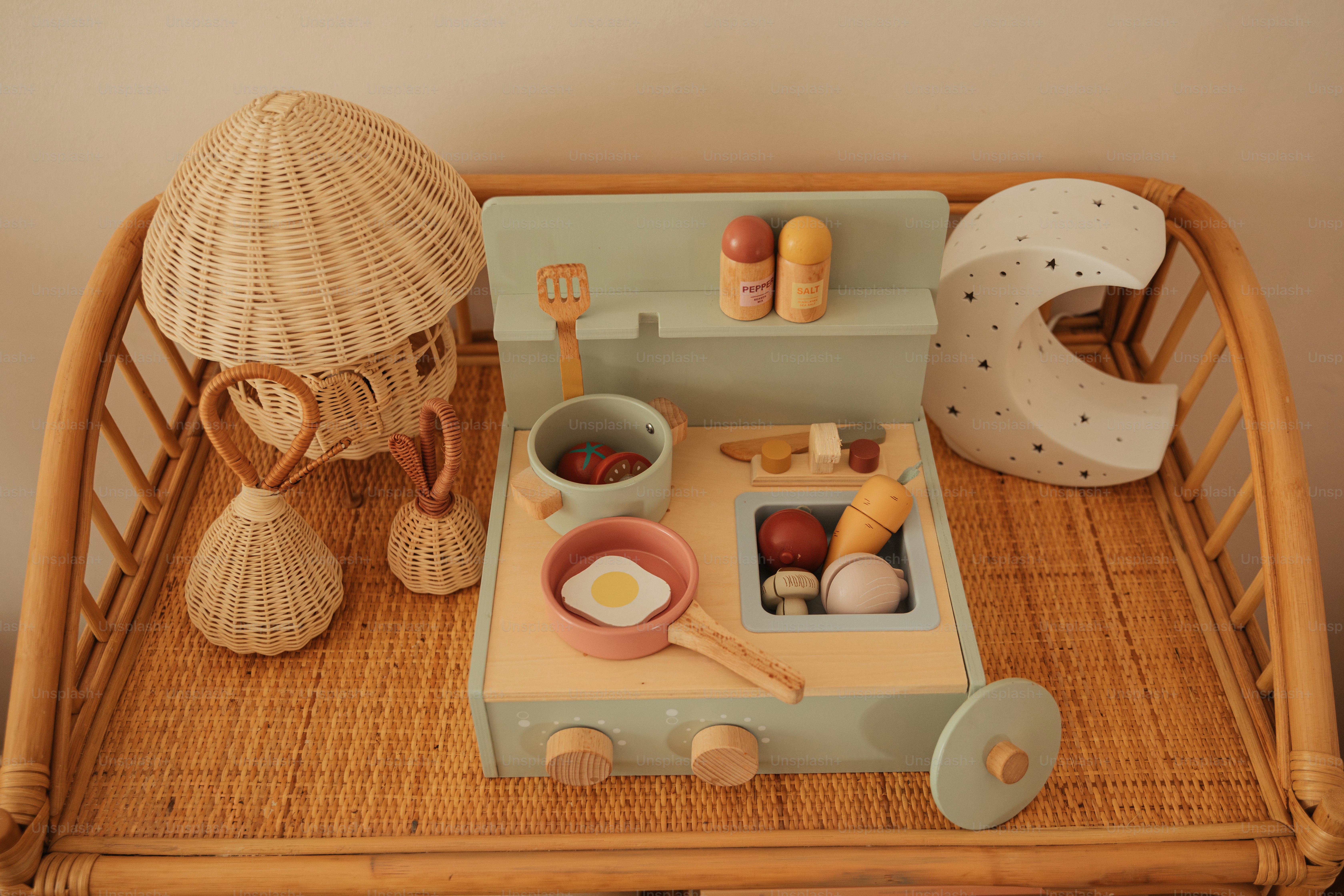 a toy kitchen set up on a wicker tray