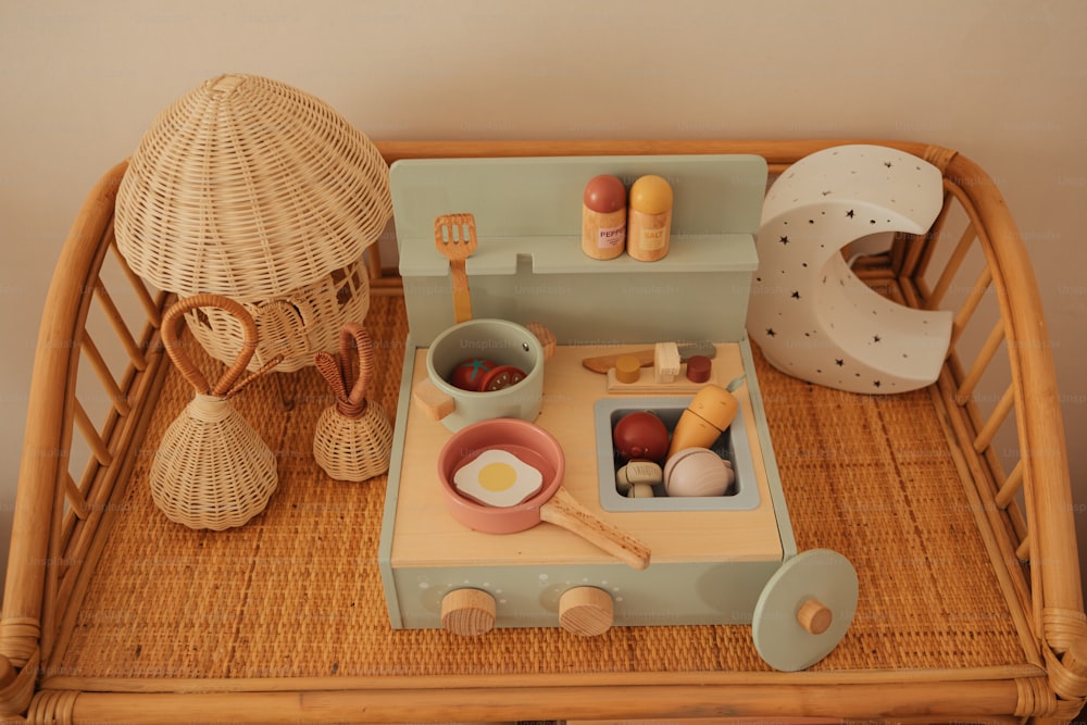 Una cocina de juguete montada en una bandeja de mimbre