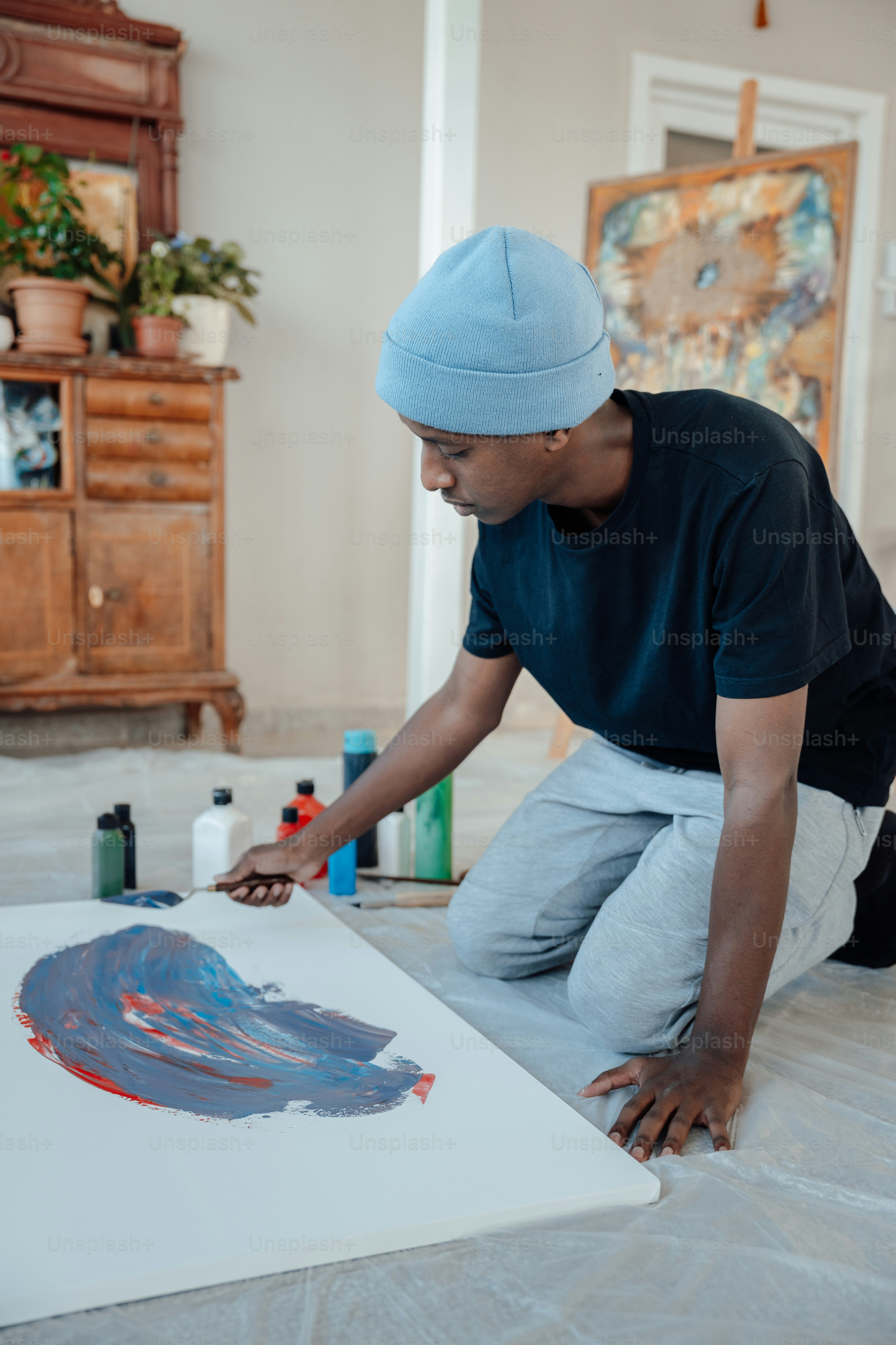 Un uomo sta dipingendo un quadro sul pavimento