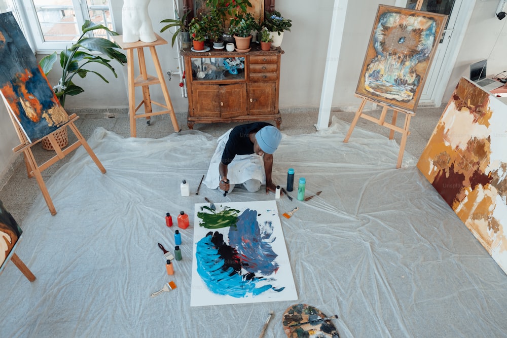 a man is painting a picture on the floor