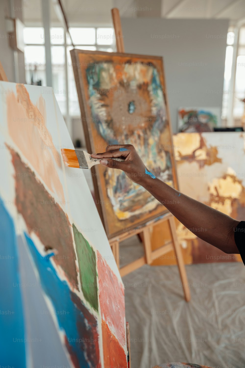 Una donna sta dipingendo su una tela in uno studio d'arte