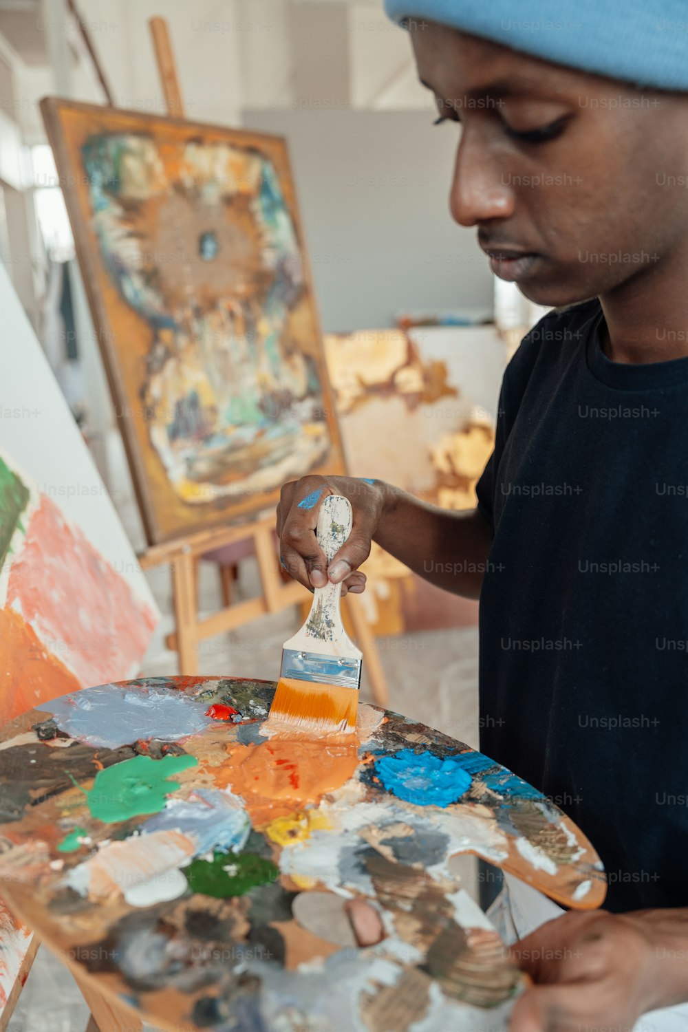 a man is painting on an easel with a paintbrush