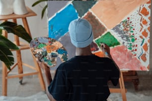 ein Mann mit Pinsel und Palette vor einem Gemälde