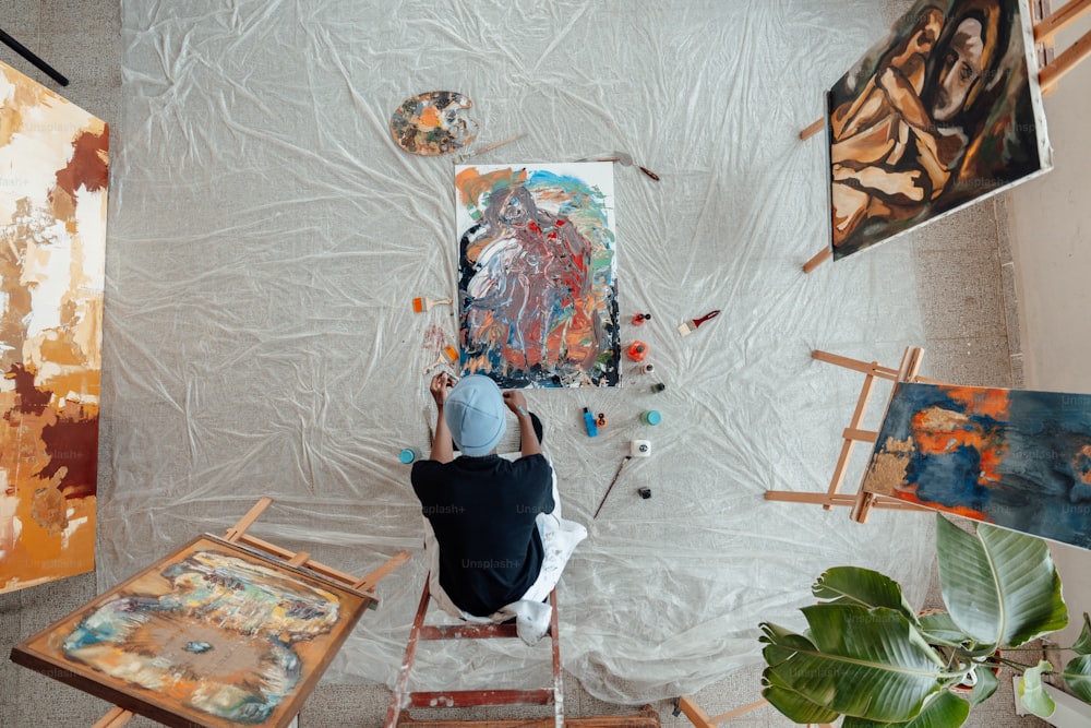 a person sitting on a chair in front of paintings