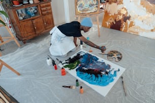 a woman is painting a picture on a canvas