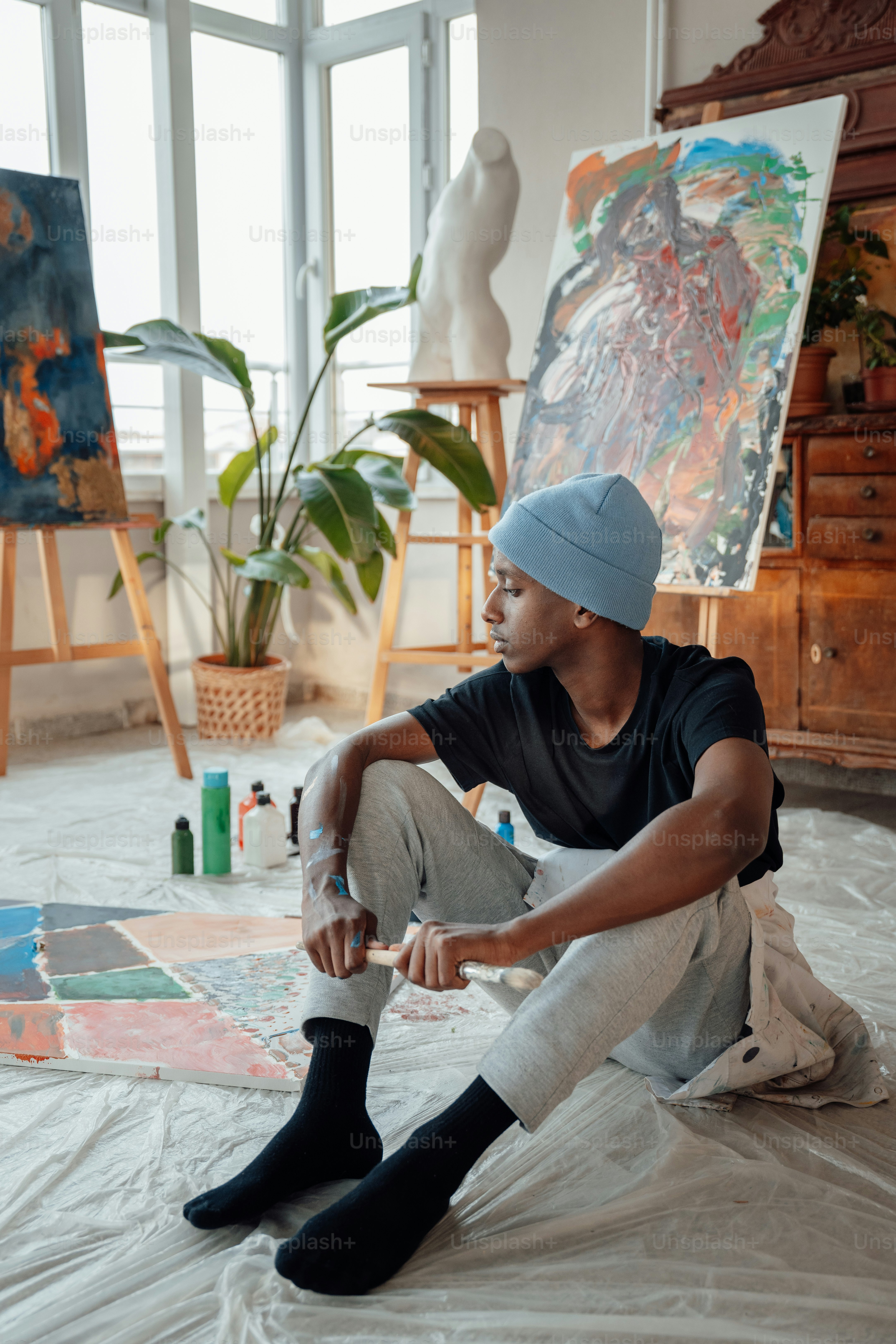 그림 앞 바닥에 앉아 있는 남자