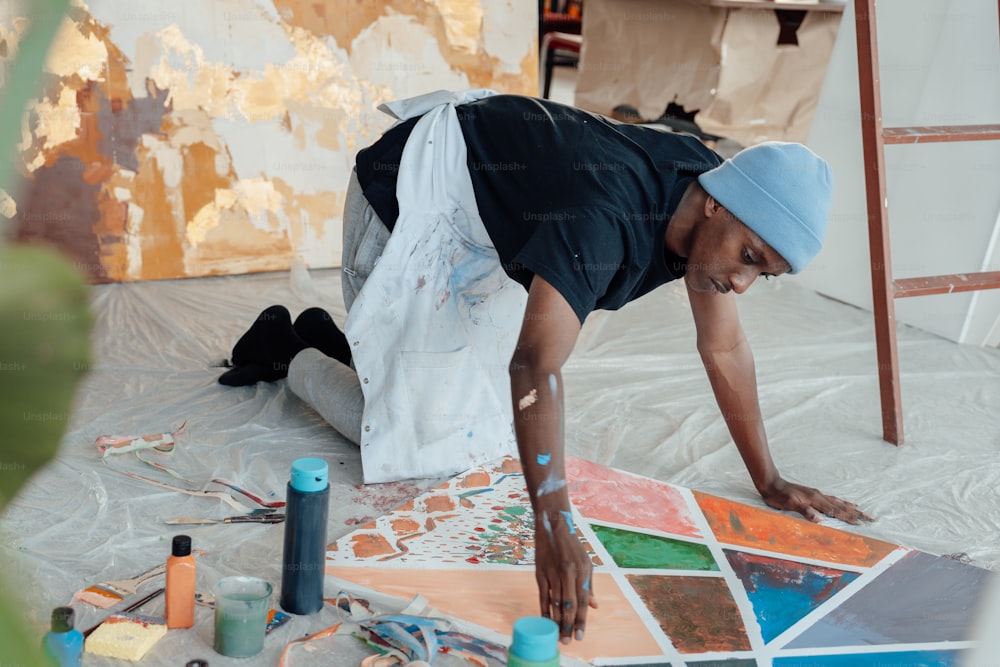 Un uomo sta dipingendo un quadro sul pavimento