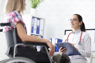 Woman in wheelchair to consult a doctor. Medical assistance to people with disabilities concept