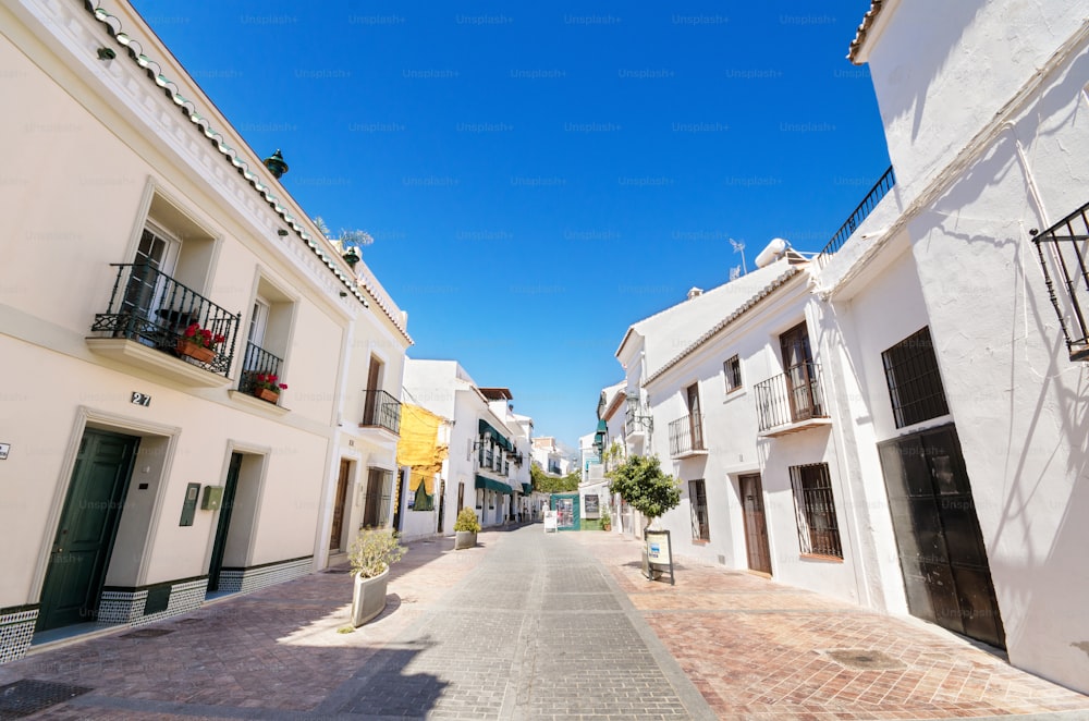 スペイン、マラガのネルハの観光村にある白い家々が立ち並ぶ典型的な通り。
