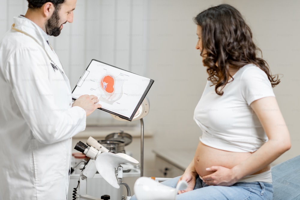 婦人科診療所での診察中に妊婦を連れた医師、理解のためのいくつかの医療スキームを示しています。妊娠中の医療と健康の考え方