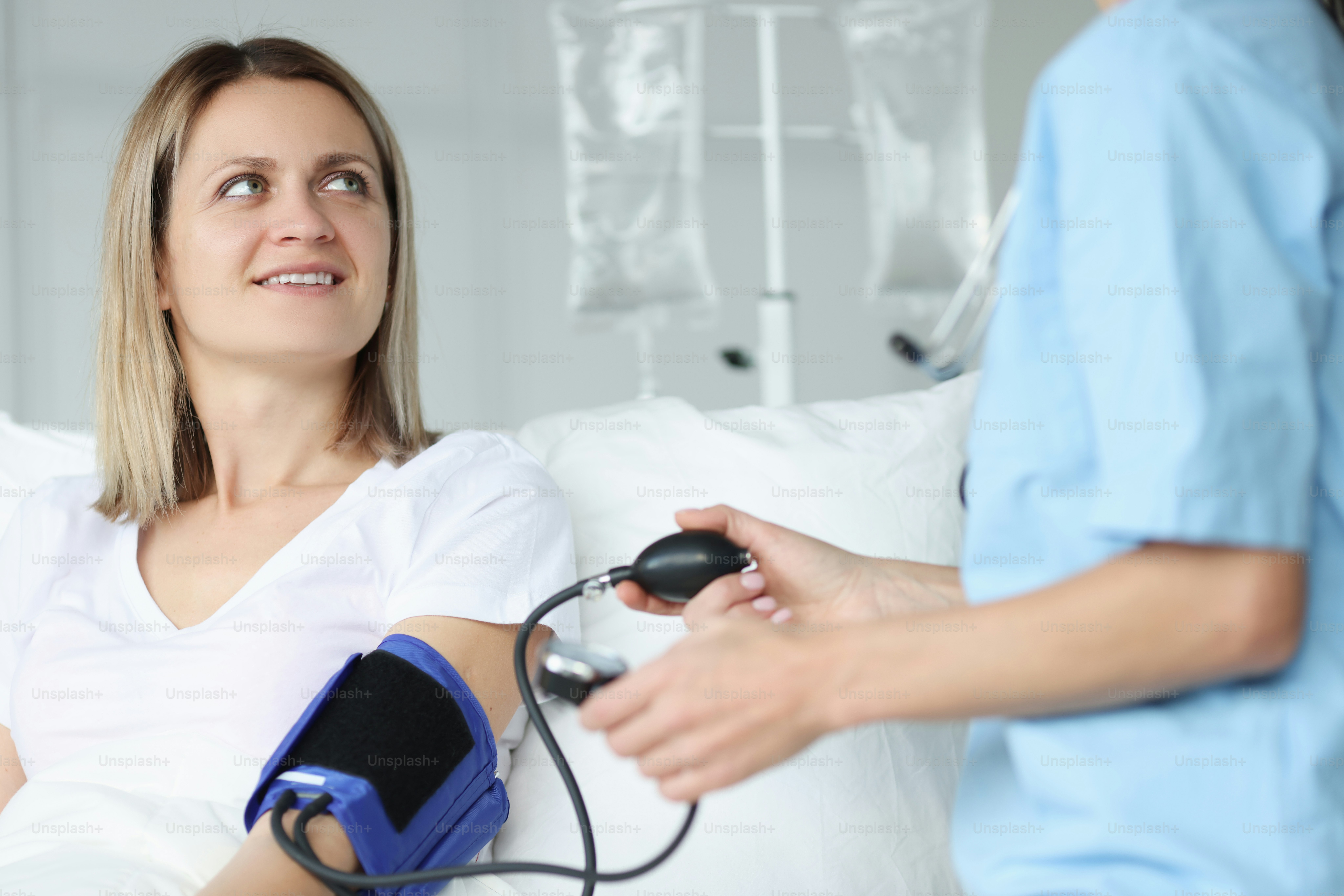 Doctor measuring blood pressure with tonometer in clinic. Arterial hypertension in pregnant women concept