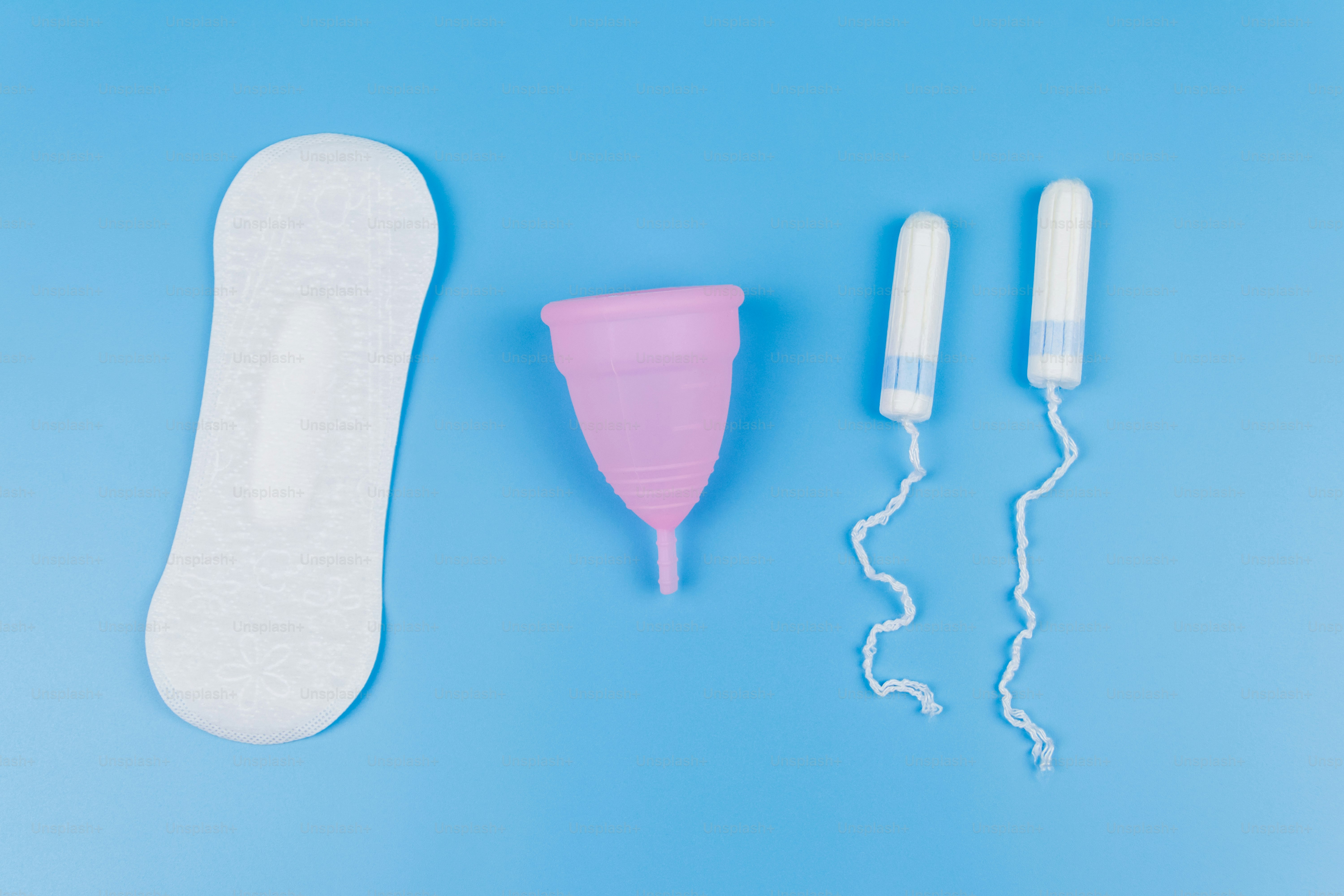 Sanitary pad, tampons and menstrual cup on blue background. Top view