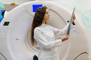 The young girl medical student in gown looks at x-ray picture of patient brain after computer tomography. CT diagnostic in medical clinic