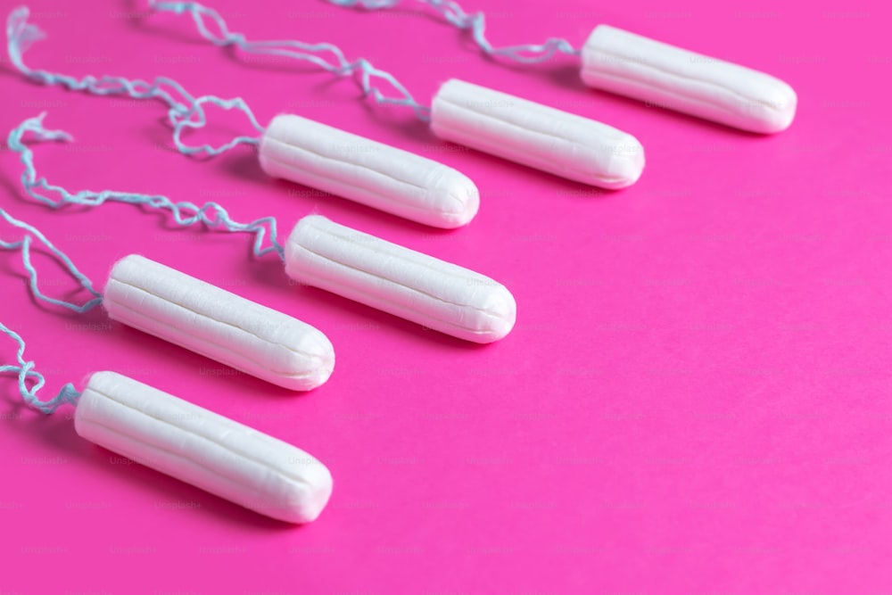 Menstrual period concept. Woman hygiene protection. Cotton tampons on pink background