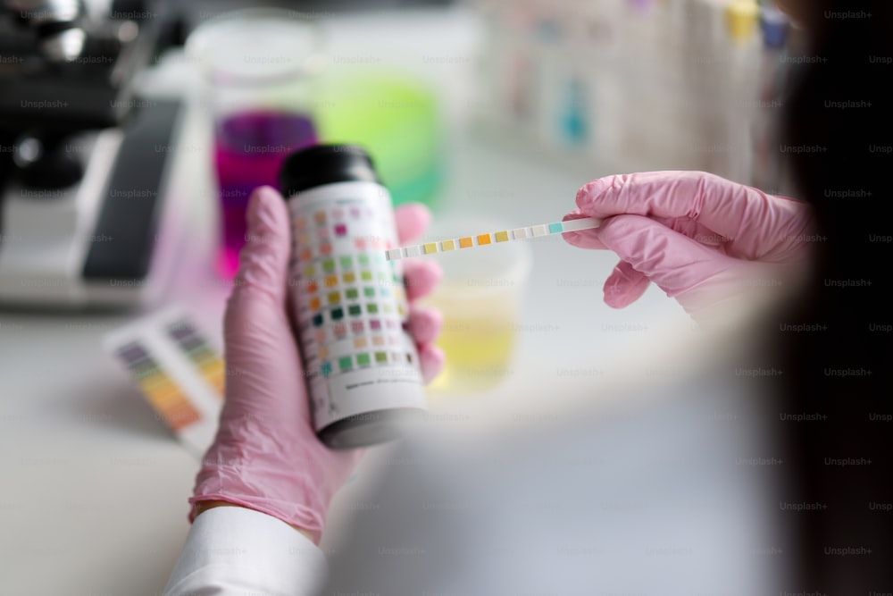 Close-up of clever scientist hold litmus test paper for soil analysis, papers show acidity, chemical experiment. Soil sampling for ph test. Lab concept