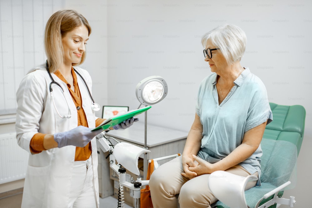 Senior woman sitting on the gynecological chair during a medical consultation with gynecologist. Concept of women's health during a menopause