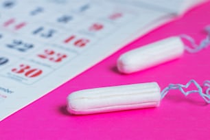 Proteção de higiene da mulher, calendário de menstruação e tampões de algodão limpos