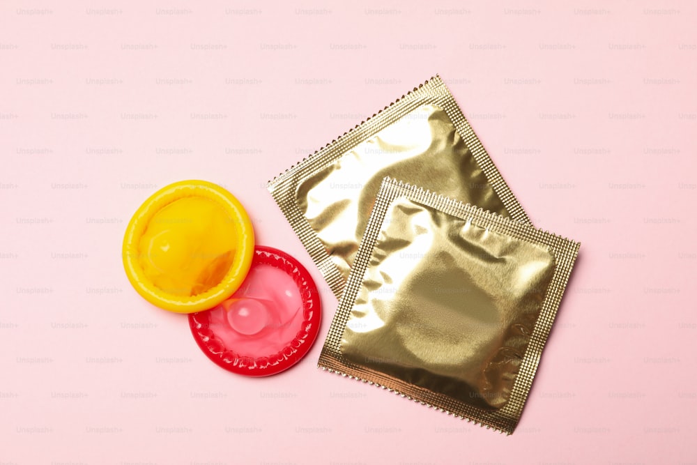 Gelbe und rote Kondome auf rosa Hintergrund