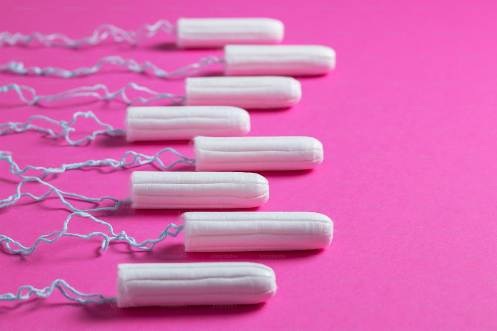 Conceito de período menstrual. Proteção da higiene da mulher. Tampões de algodão no fundo cor-de-rosa