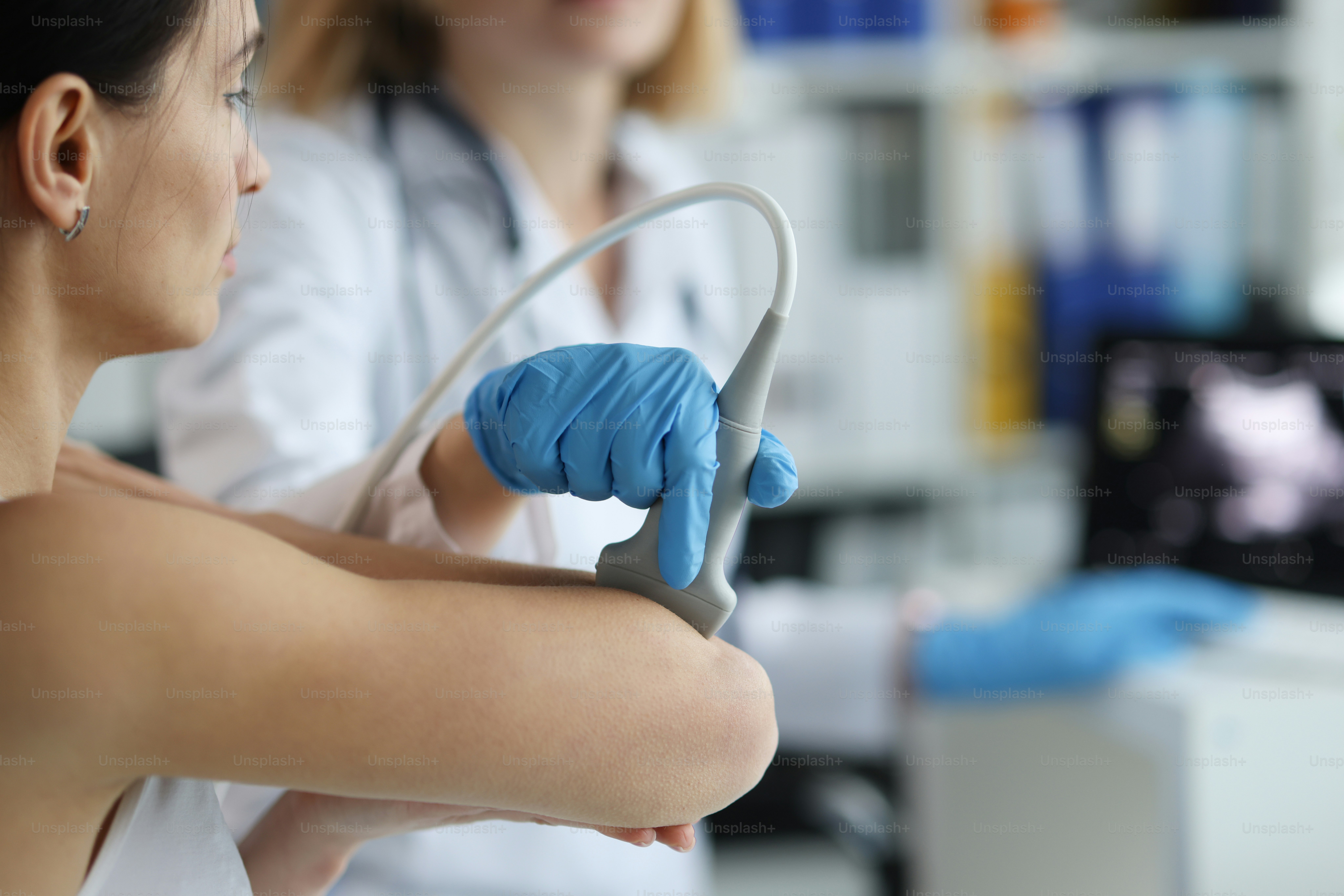 Paciente com médico ortopedista faz ultrassom da articulação do cotovelo na clínica. Pesquisa médica e conceito de ossos de artrite