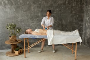 Concentrated female medical therapist applying cupping bubble massage to glad relaxing patient stomach. Alternative Chinese rubbing medicine. Acupressure, body and skin care, treatment in spa salon.