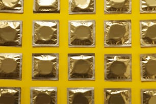 Flat lay with blank condoms on yellow background