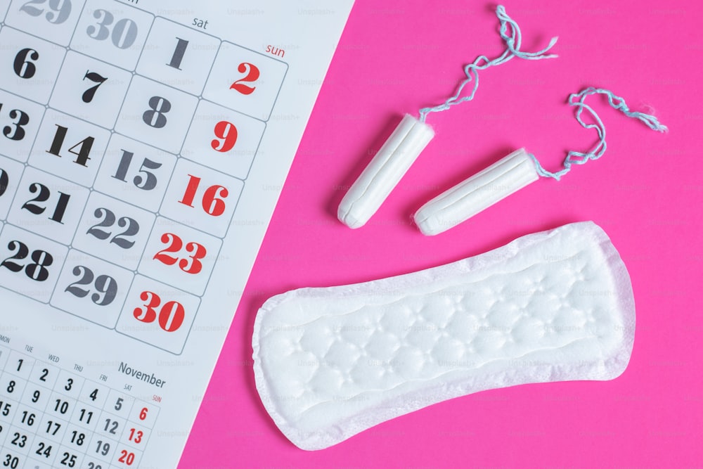 Protección de la higiene de la mujer, calendario de la menstruación y tampones y compresas de algodón limpios