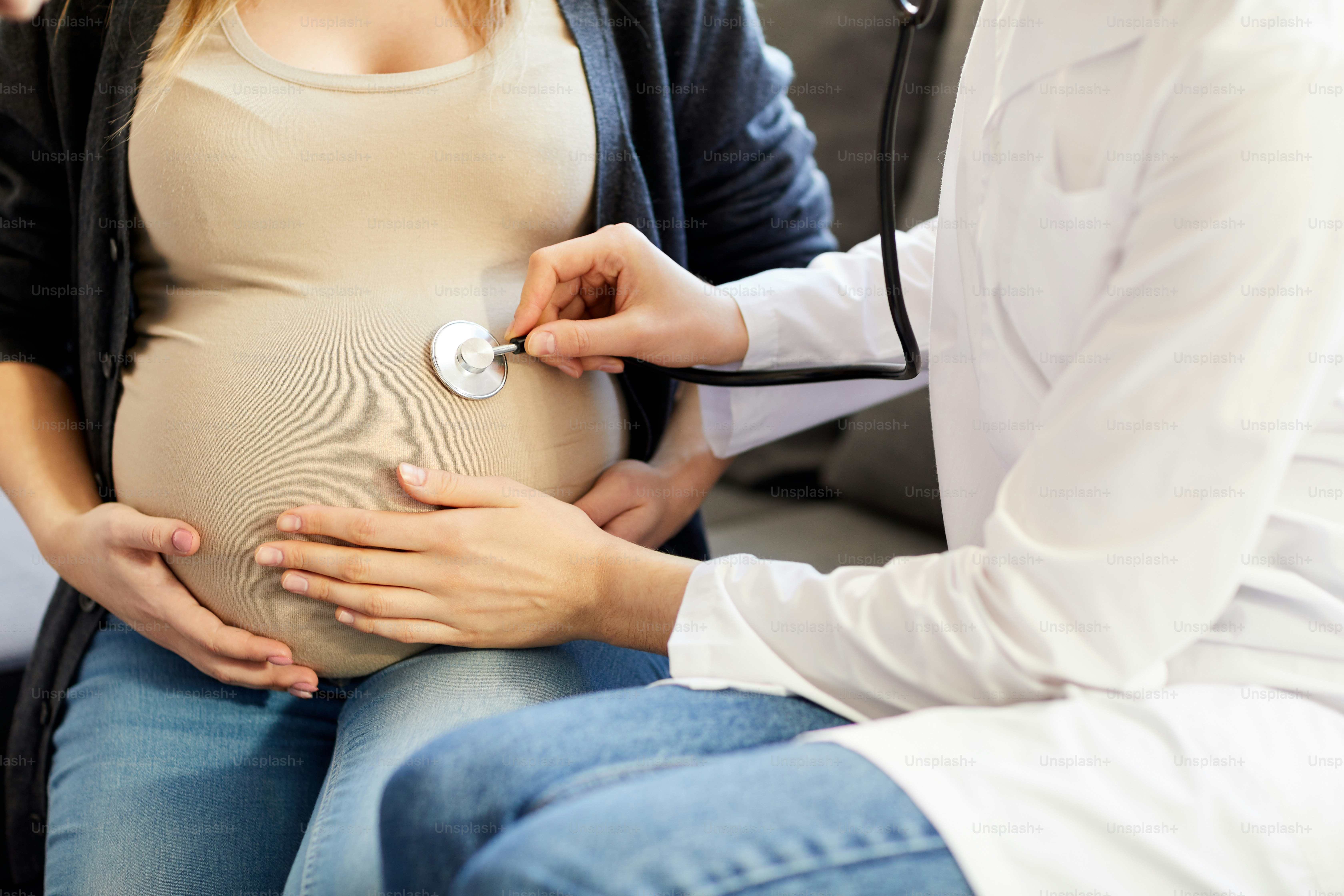 Nahaufnahme eines nicht erkennbaren Geburtshelfers, der dem Herzschlag des Babys lauscht und das Thetooskop an den Bauch der Schwangerschaft anlegt, Kopierraum