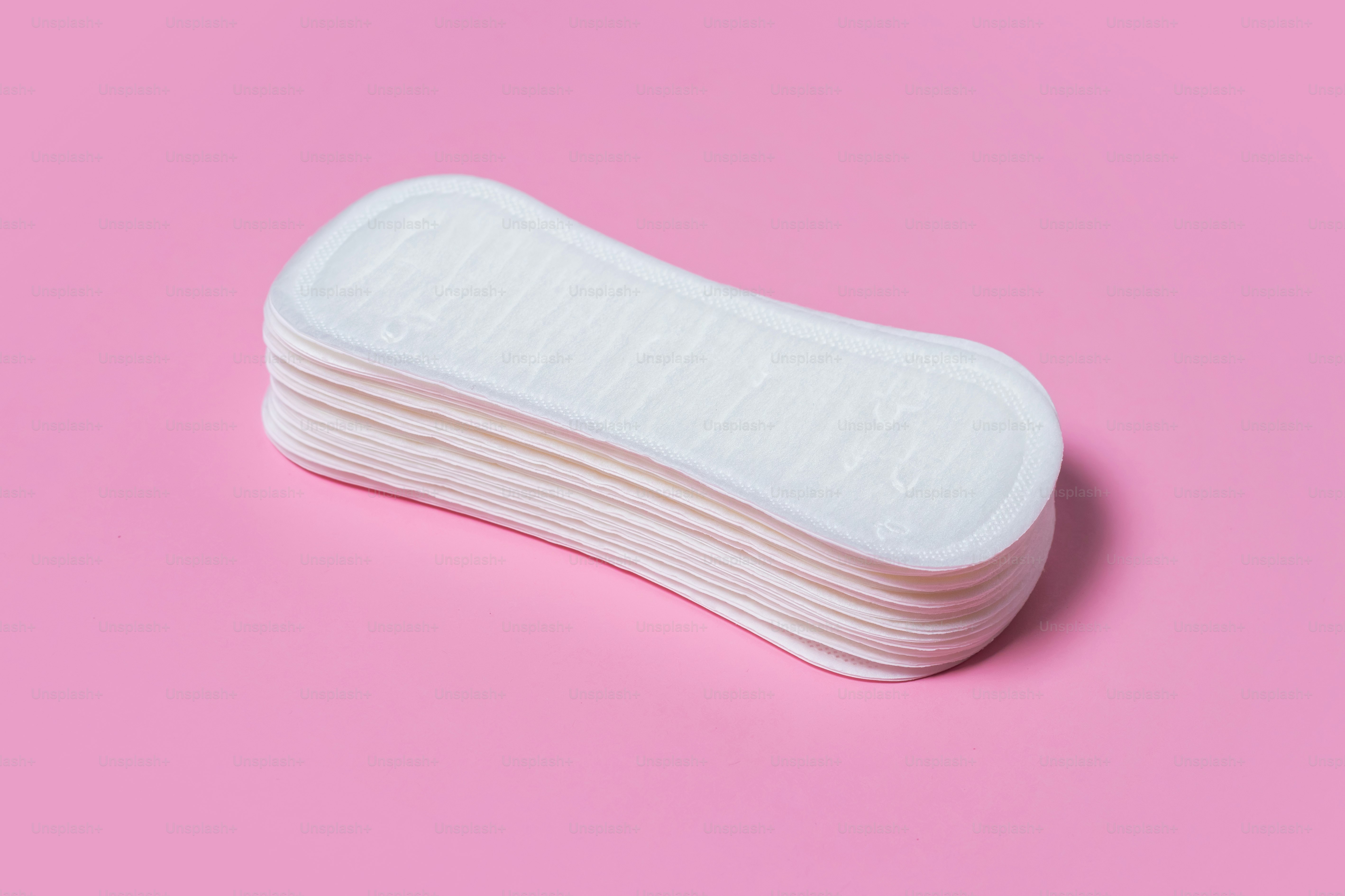 Feminine hygiene pads on a pink background. Concept of feminine hygiene during menstruation