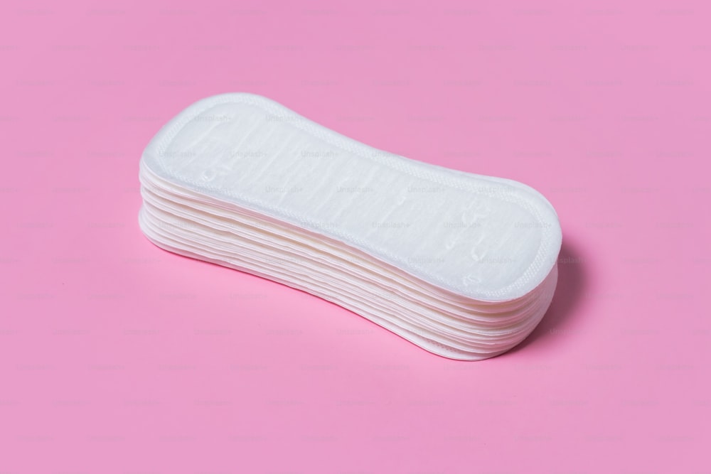 Assorbenti igienici femminili su sfondo rosa. Concetto di igiene femminile durante le mestruazioni