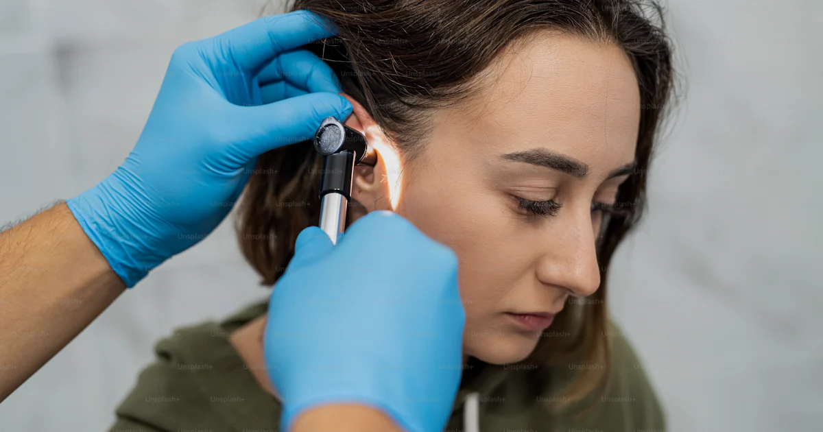 Otoscpy Advanced examination of a woman's ear using an otoscope at a doctor's ...