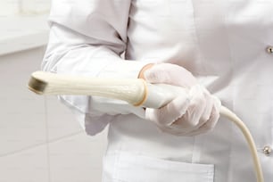 Gynecologist holding transvaginal ultrasound wand to exam woman