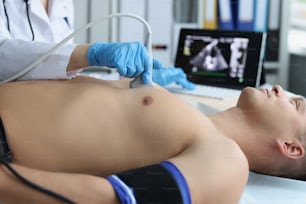 Gros plan d’un médecin faisant une échographie de la cage thoracique, d’un cardiologue examinant le cœur d’un patient. Personne en examen programmé à l’hôpital. Concept d’échographie et de soins de santé