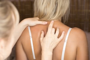 Inspection of backbone by doctor. Neurologist examines cervical vertebrae of female patient spinal column in medical clinic. Neurological physical examination. Osteopathy, chiropractic, physiotherapy.