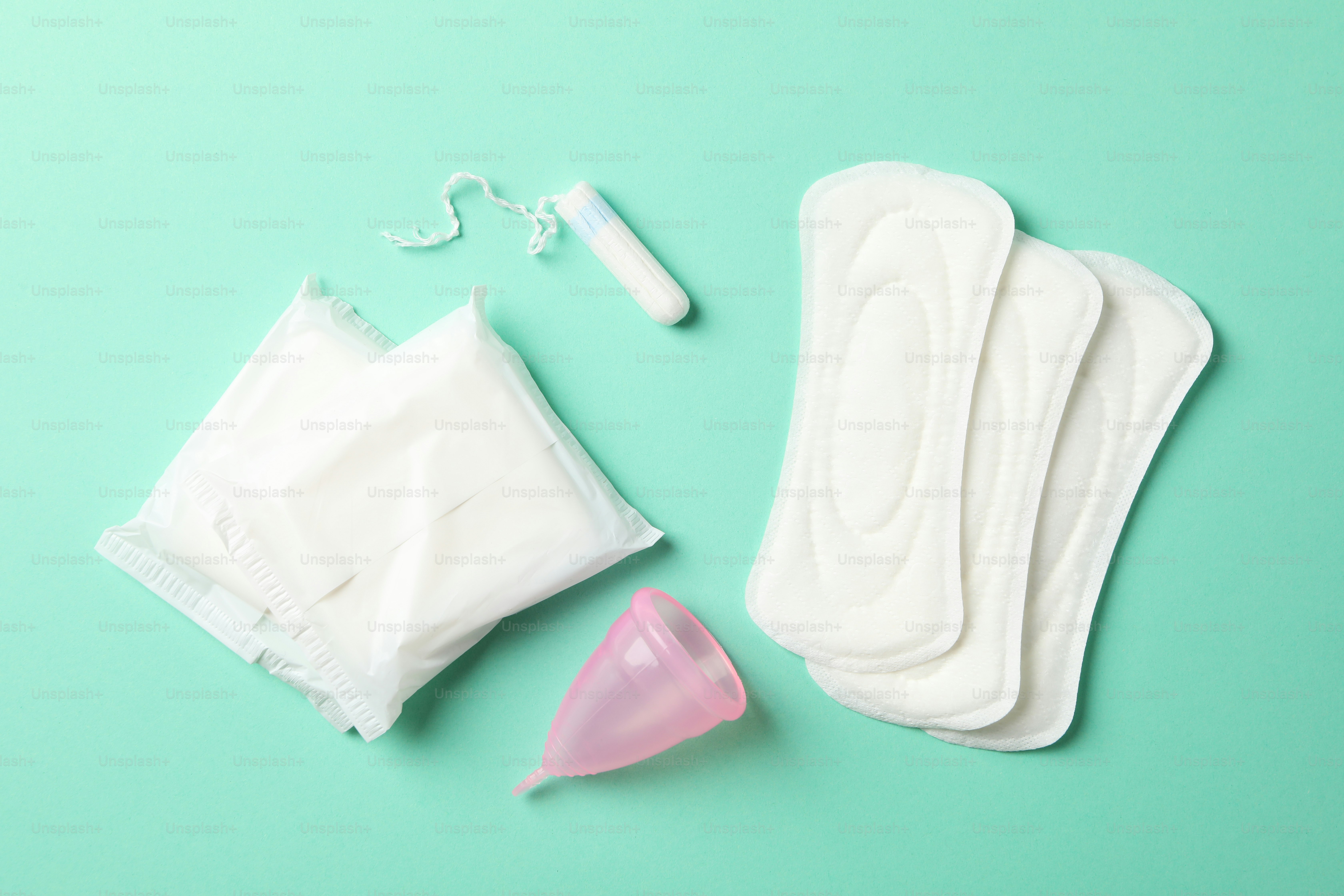 Menstruation period concept on mint background, top view