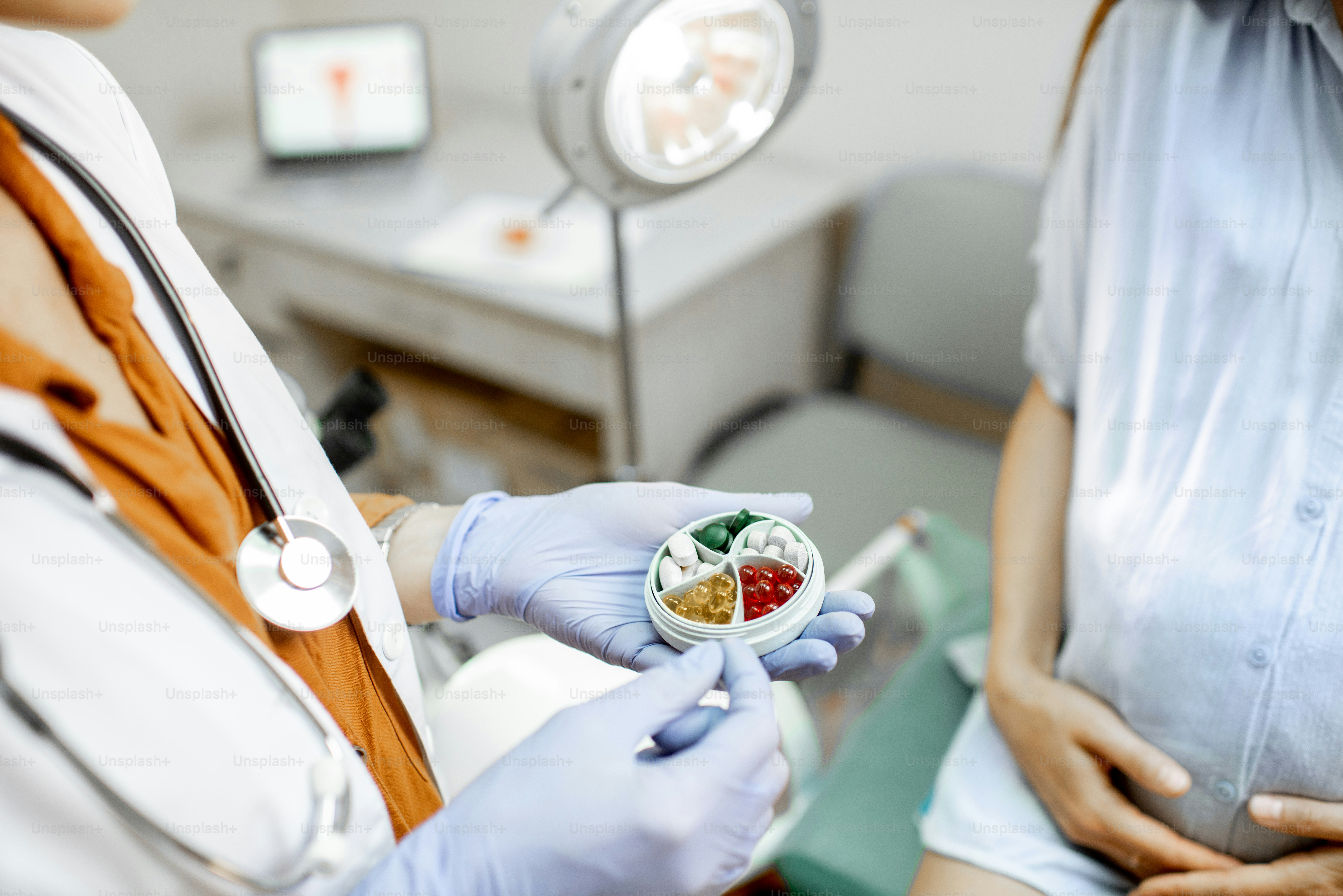 Doctor holding pillbox with some medicine in the gynecological office, close-up view on the hands and pills