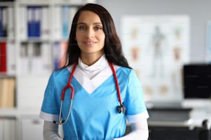 Porträt eines gut aussehenden jungen Mediziners in Uniform und rotem Stethoskop. Professionelle Krankenschwester, die Menschen in der Klinik hilft. Modernes Medizin- und Krankenhauskonzept