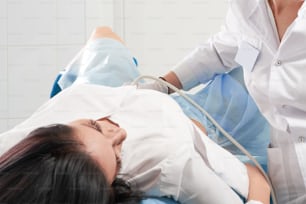 Gynecologist doing ultrasound scanning with Diagnostic equipment for a woman