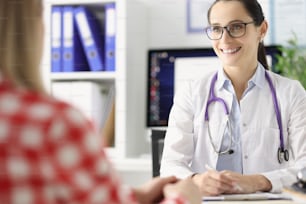 Smiling female doctor conducts medical appointment to female patient. Medical services concept